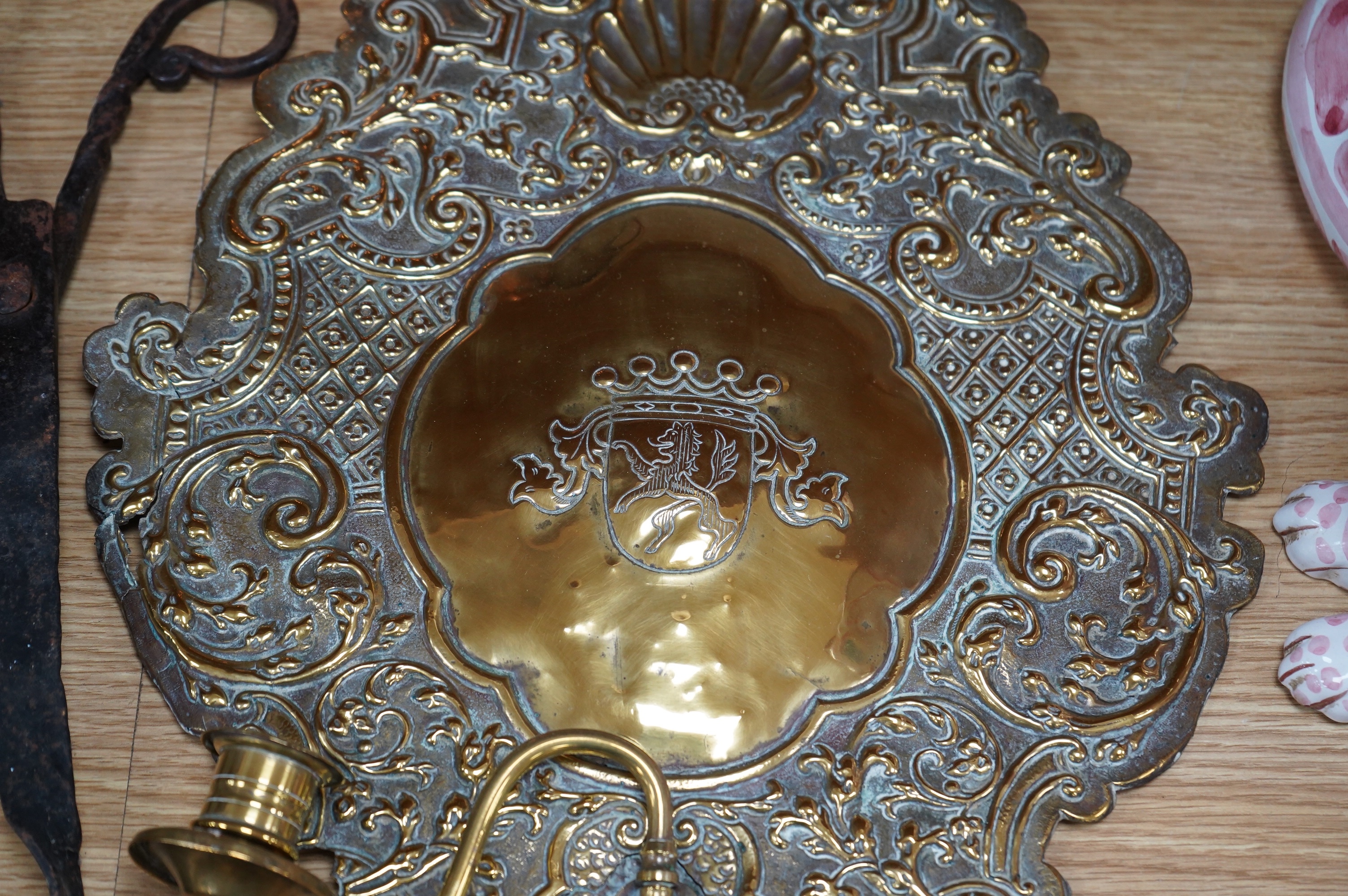 A pair of brass repousse wall sconces, a copper two handle mug, a small brass sun dial, a pair of tongs and a roasting trivet. Condition - poor to fair